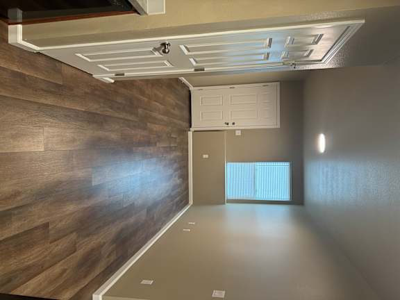 A modern room with a white door and a wooden wall.