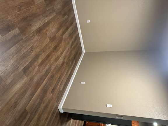 A corner of a room with a wooden floor.