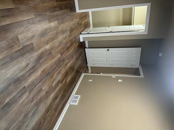 A white ventilation hood is installed on a wooden wall.