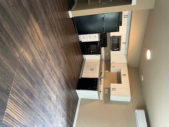 A wood floor with a white cabinet and drawers.