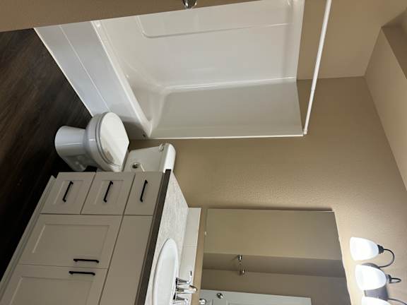 A white sink in a bathroom with a white cabinet above it.