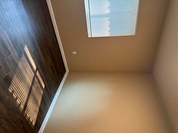 A room with a window and wooden flooring.
