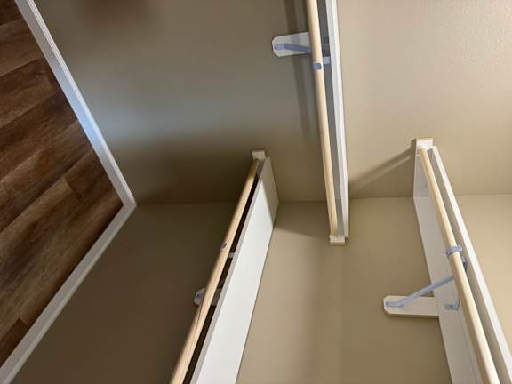 A white ladder is leaning against a wall.