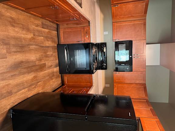 A kitchen with wooden cabinets and a black countertop.