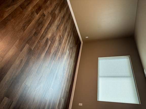 A room with a skylight and wooden flooring.