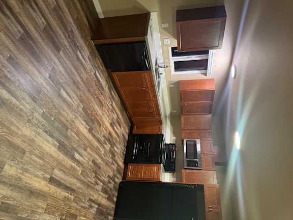 A kitchen with wooden cabinets and a black countertop.