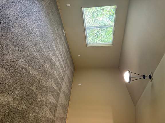 A small window in a room with a light on the ceiling.