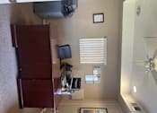 Thumbnail 14 of 27 - A room with a ceiling fan, a window with blinds, and a cabinet with a monitor on top.