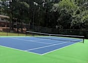 Thumbnail 12 of 33 - A tennis court with a blue and green surface.