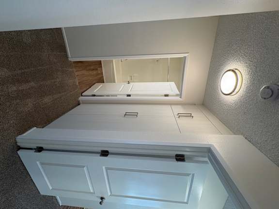 A white ceiling with a light fixture and a mirror.