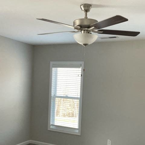 a ceiling fan in a room with a window