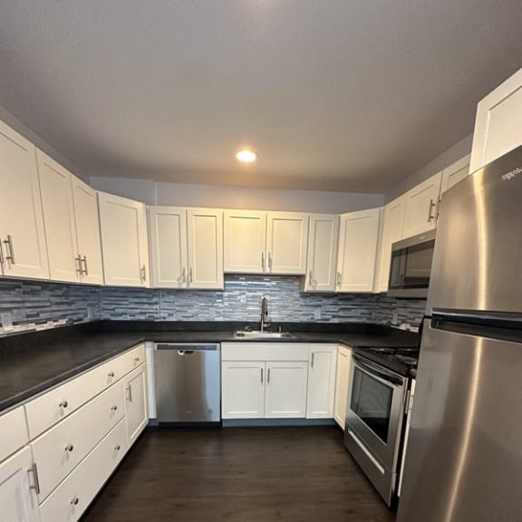 view of a kitchen with a refrigerator and microwave at Carisbrooke at Manchester Apartments, Manchester, New Hampshire