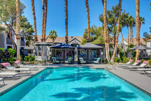 Pool desk with lounge chairs and the club house in the background.