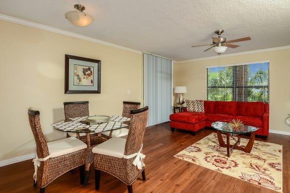 Livingroom / Dining room combo with hard wood style flooring, light fixture over table and ceiling fan in the Livingroom.