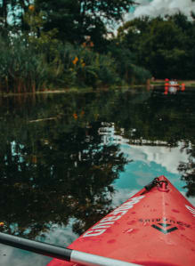 a red kayak in the water on a river at The Villages Apartment of Bayan Grove in Boynton Beach, FL
