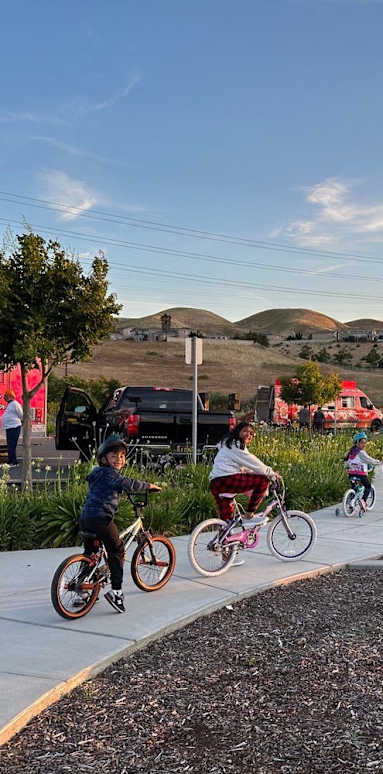 a group of children riding bikes on a sidewalk