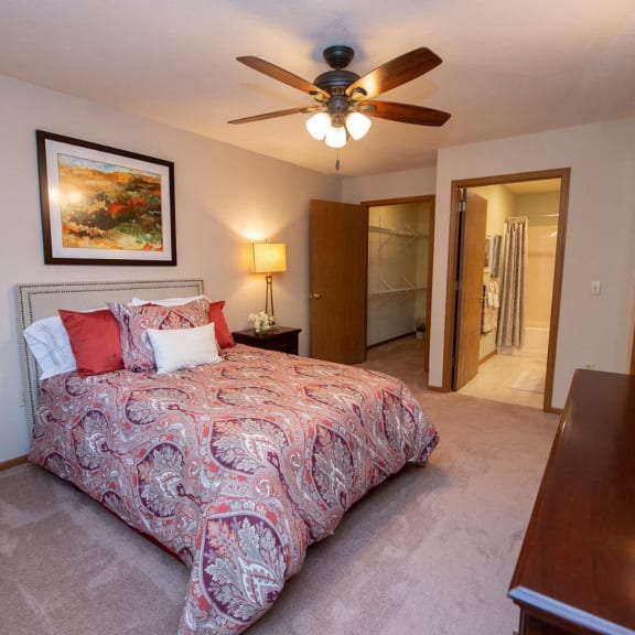 a bedroom with a bed and a ceiling fan