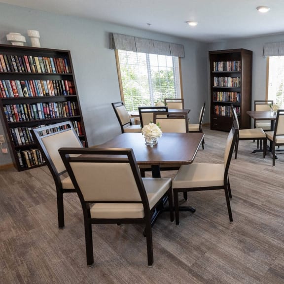 a dining room with a table and chairs and bookshelves