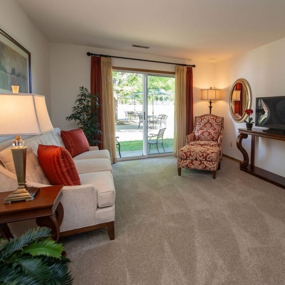 a living room with a couch and a chair and a sliding glass door