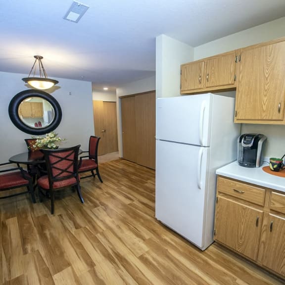 a kitchen with a refrigerator and a dining room table