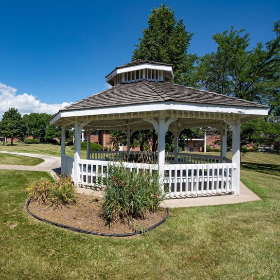 a white gazebo in the middle of a park