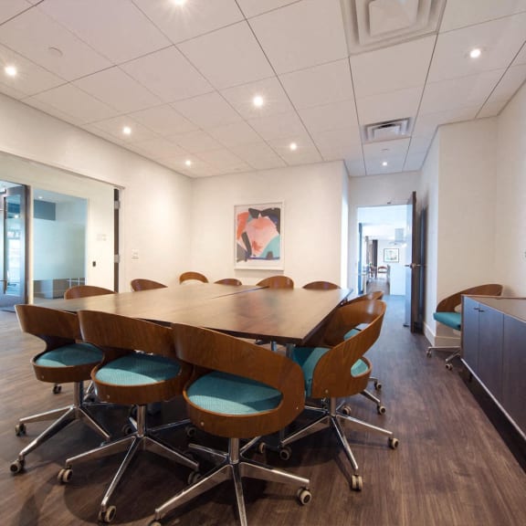 a conference room with a long wooden table and chairs at Versus, Calgary, Alberta, T2R 1A8