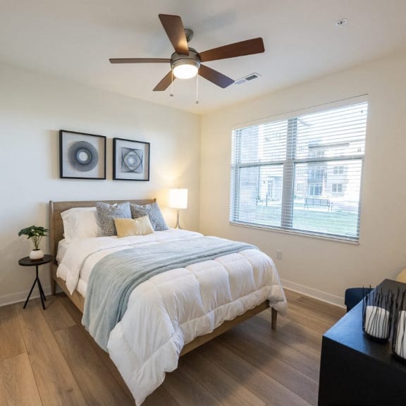 a bedroom with a ceiling fan and a bed