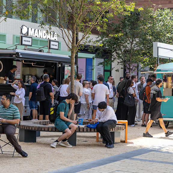 A group of people are gathered outside of a Mandala food truck.