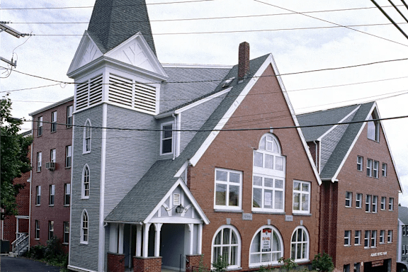 A church with a steeple and a clock on the front.