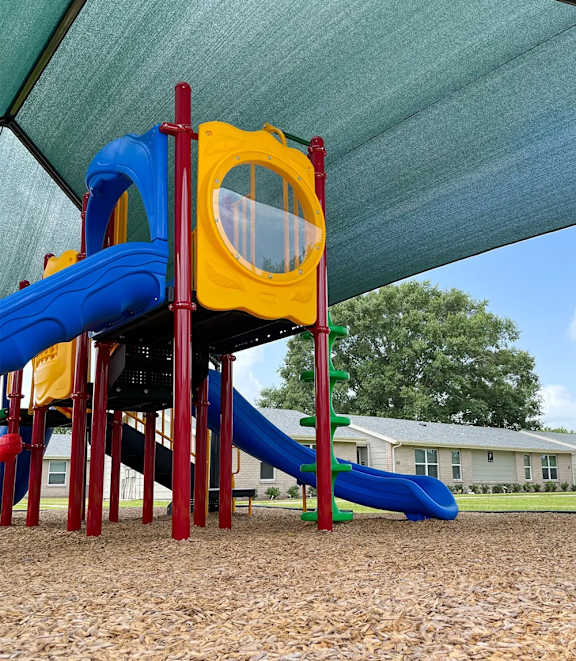 A playground with a blue and yellow slide.