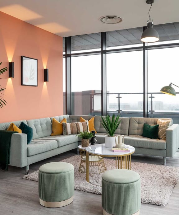 a living room with couches and tables in front of a window