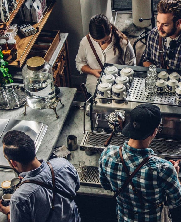 people working in a coffee shop making cupcakes