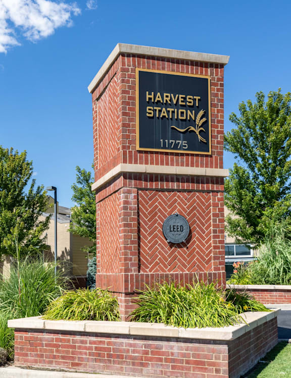 A brick pillar with a sign that says Harvest Station 1775.