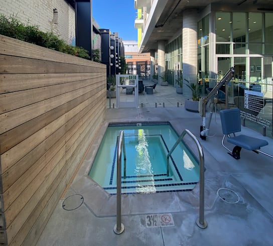 A small pool with a metal railing is surrounded by a wooden fence.