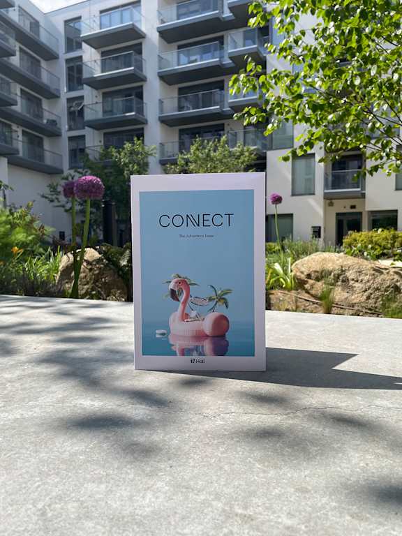 A sign with the word CONECT and a picture of a flamingo is in front of a building.