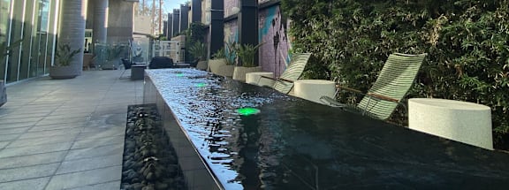 A long black bench with a water feature in the middle.