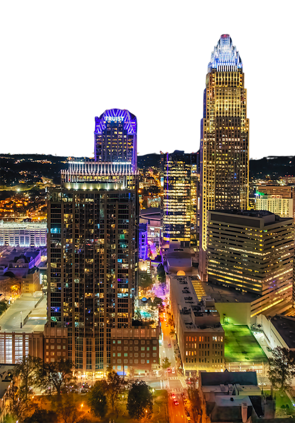 A long exposure shot of a city skyline at night with light trails on the road.