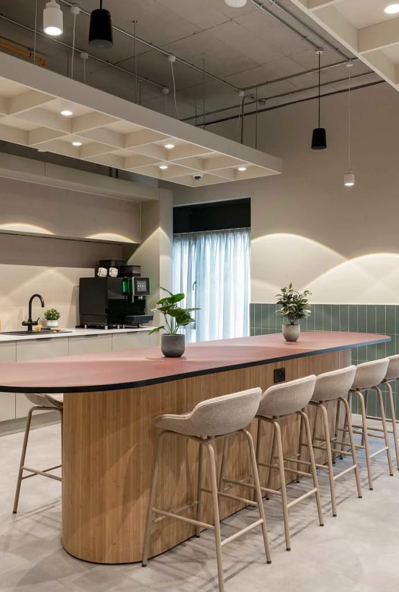 a bar in a room with chairs and a sink