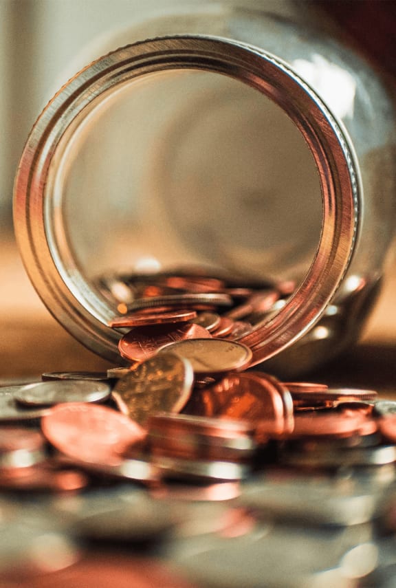 a jar filled with coins on a table