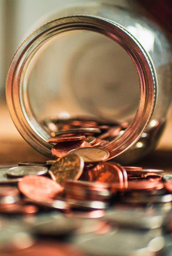 a jar filled with coins on a table