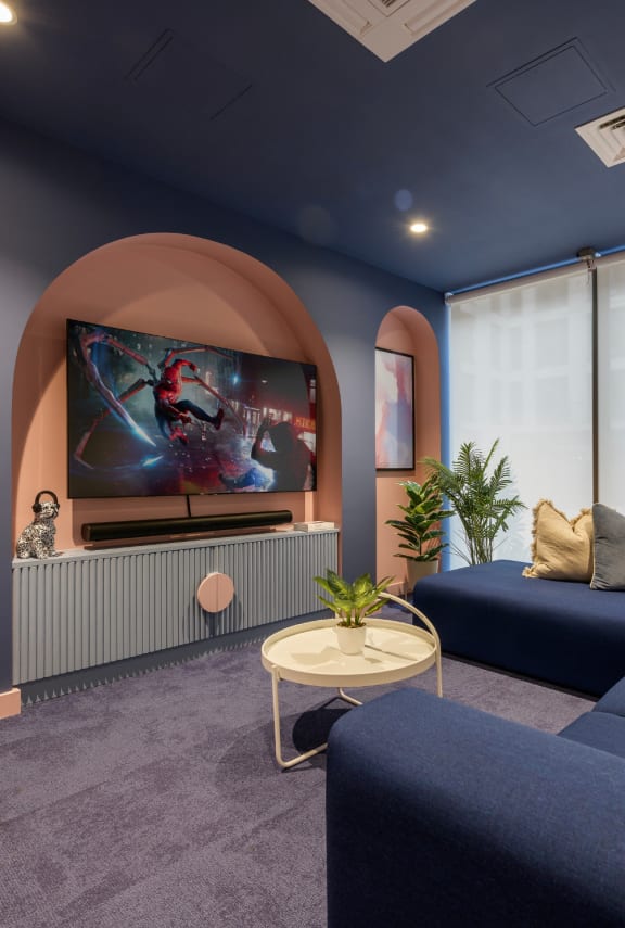 a living room with a large screen tv and a blue couch