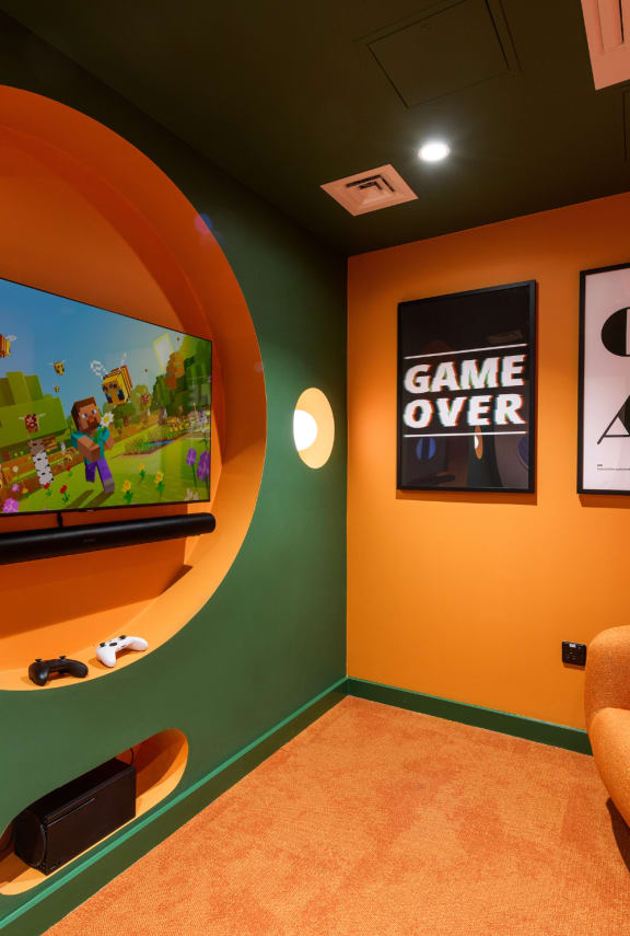 a living room with a blue couch and a tv on the wall