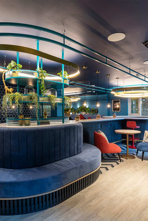 a blue bar with a blue couch and chairs in a restaurant