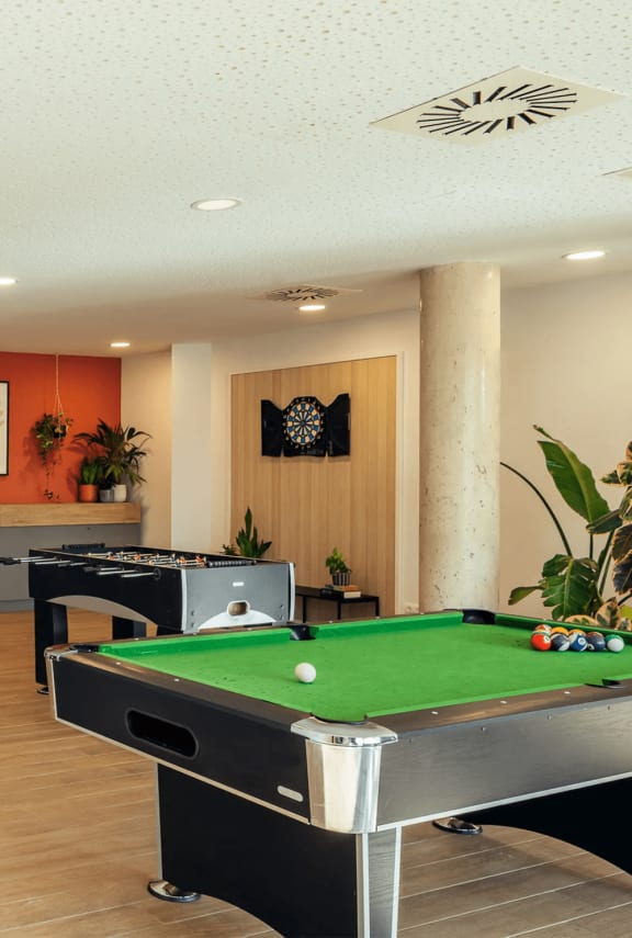 a games room with a pool table and a dart board