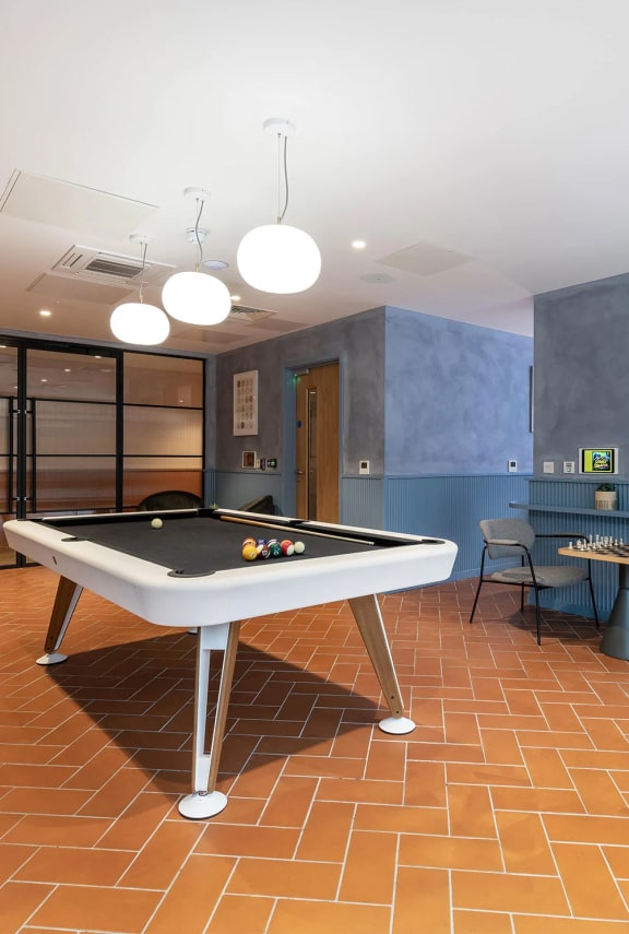 a pool table in a game room with a bar
