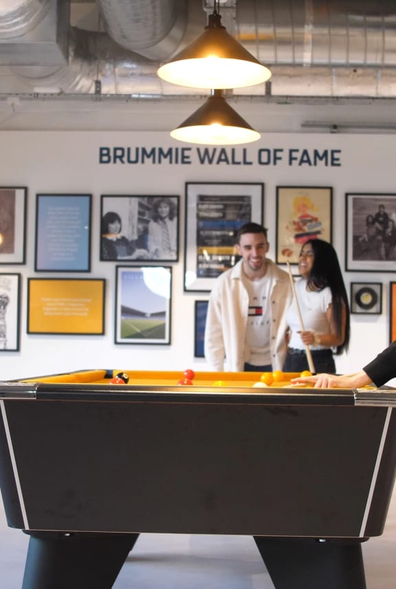 a man and woman playing a game of pool at the brunswick wall of fame