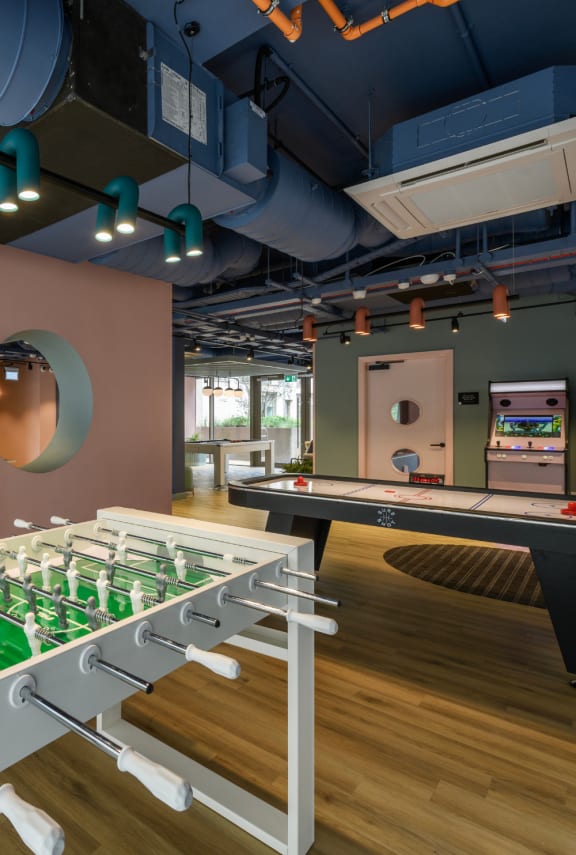 a recreation room with a foosball table and a pool table