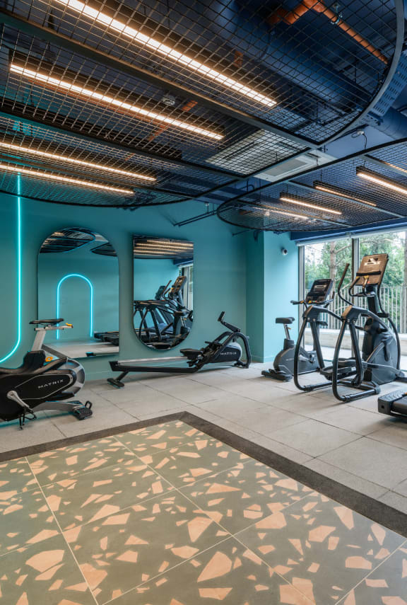 a gym with luggage on the floor and exercise machines