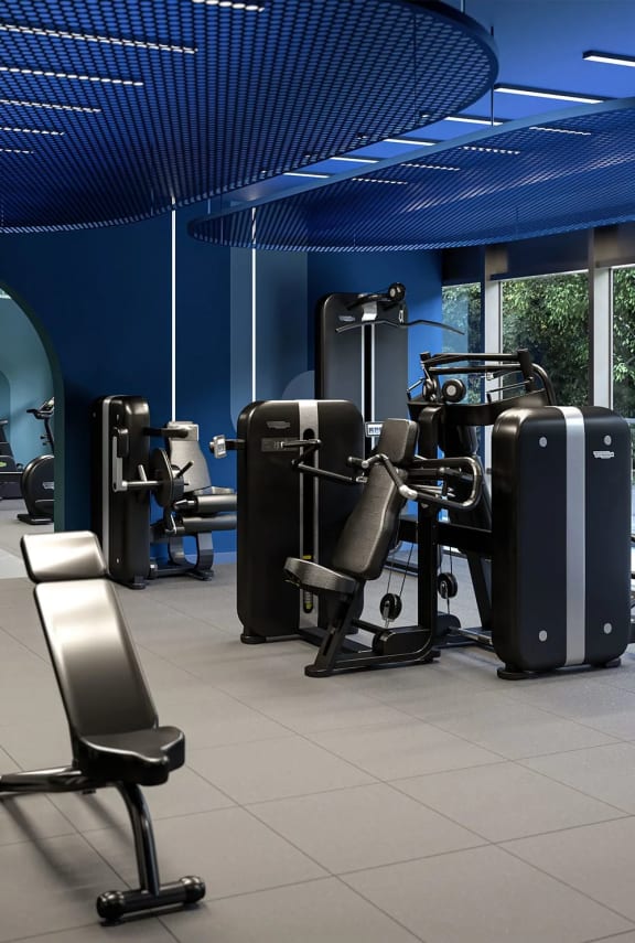 a gym with luggage on the floor and exercise machines
