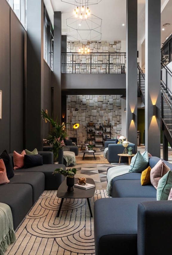 the lobby of a hotel with couches and a table